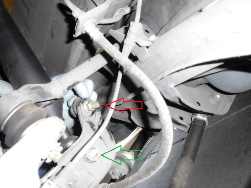 The sway bar end link (red arrow) and lower shock mount bolts (green arrow)