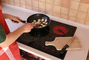 Someone cooking food on an induction cooktop.