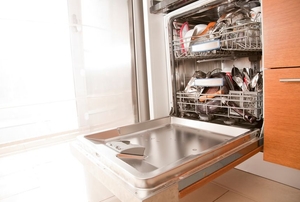 A dishwasher with a door hanging open in a bright room.