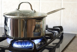 A gas stove with a pot on it.