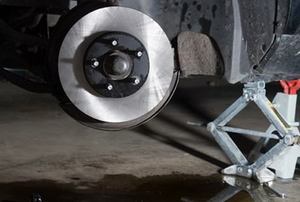 A car lifted off of the ground for a look at the brakes.