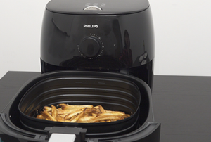 A Philips Airfryer with fries in the basket.