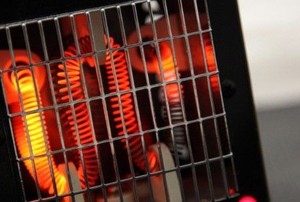 a heater with a protective metal grid and red coils