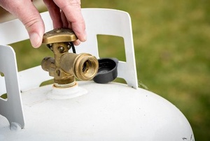 man opening propane tank valve