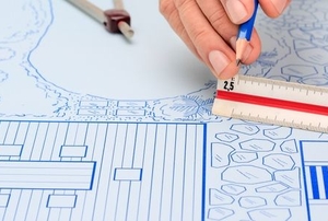 hands drawing architectural plans for a deck