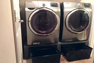washer and dryer on pedestal with bins