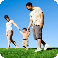 A young boy holding hands with his parents while walking