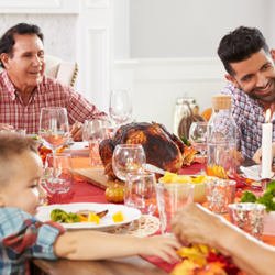 Multi generational family gathered at a well lit Thanksgiving table