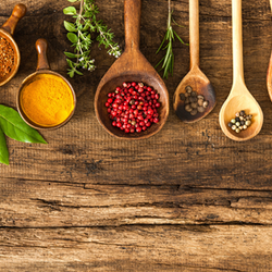 Wooden spoons and cutting board filled with herbs and spices