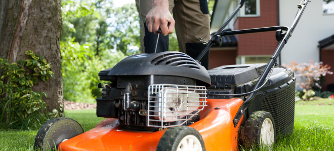 man pulling the cord on a lawn mower engine