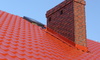 Chimney protruding from a red roof
