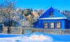 A blue house in a snowy neighborhood.