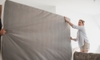 two people moving a large mattress