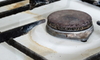 rusty gas stovetop with spilled water
