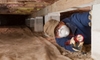 person wearing a mask in a crawlspace
