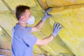 Person installing insulation in an attic