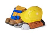 A pile of safety gear including a hard hat and gloves against a white background. 
