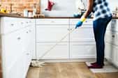 A woman cleans wood floors.