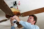 A man wiring a ceiling fan.