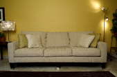 Tan couch against yellow wall
