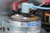A close image of an air conditioner capacitor.
