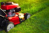 A red lawn mower cutting grass.