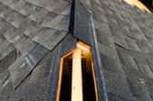 The hole for a ridge vent on a partially-shingled roof.
