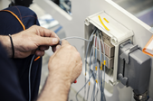 man working with wires in a control panel