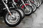 The front wheels of a line of motorcycles.