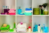 Hand towels and soaps neatly organized on bathroom shelves.