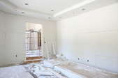 A room under construction with bare, sheetrock walls.