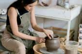 woman working on pottery in home studio