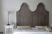 bed with tall, wooden headboard