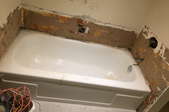 bathtub with wall materials removed around it during construction