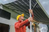 man holding pole supporting rv awning