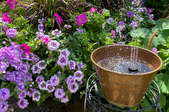 flower garden with solar fountain in brass bucket