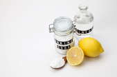 Natural cleaning supplies including a lemon, baking soda, and vinegar. 