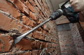 A brick wall in the process of repointing with a drill. 