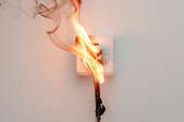 a burning electrical cord and socket
