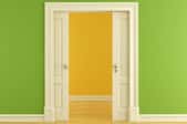 a pocket door between a yellow and green room