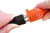 Plugging an electrical cord into an orange extension cord. 