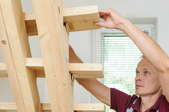 man building set of narrow loft stairs