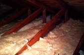 Fiberglass insulation on an attic floor, between the joists.