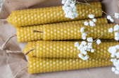 wrapped beeswax candles with small white flowers