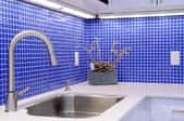 kitchen counter with walls of small blue tile backsplash