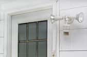 A back or side door with motion detector security lights installed beside it.
