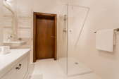 A standing shower with a glass enclosure.