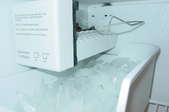 Ice maker full of ice inside a refrigerator
