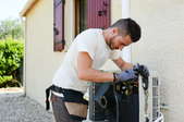 man working on an outdoor central air conditioning unit