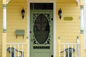 porch of yellow house with mint green front door